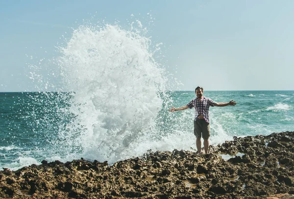 Молодий чоловік стоїть на березі в розпилювачі від аварійних хвиль — стокове фото