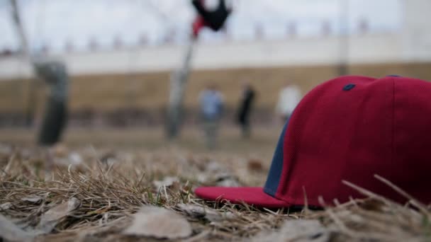 Street acrobatico - adolescenti corridori liberi Esecuzione salti mortali al parco autunnale - de-focalizzato di fronte al berretto di moda — Video Stock