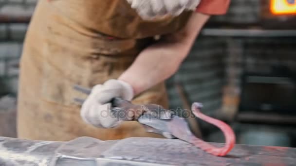 El herrero dobla varilla de hierro en el yunque con martillo, trabajo de metal — Vídeos de Stock