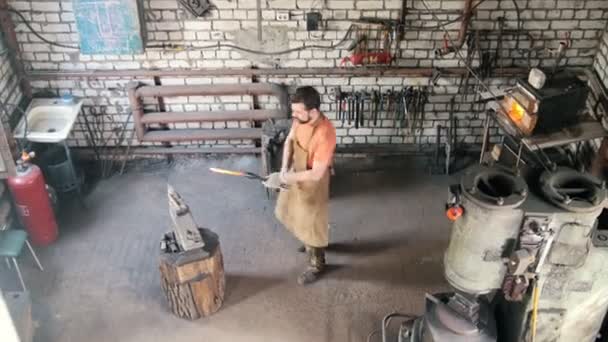 Homem barba ferreiro em forja faz ferramentas de metal em bigorna de ferro com martelo, vista superior — Vídeo de Stock