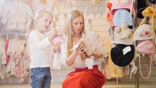 Madre e hija consideran gorro de bebé — Foto de Stock