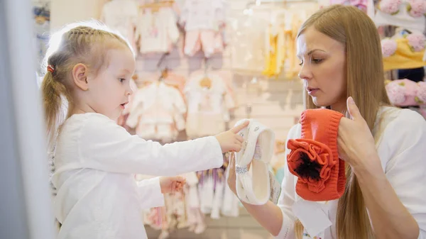 Mamá muestra hija blanco y naranja vestidor — Foto de Stock