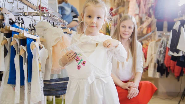 Aranyos lány tartja kezében egy könnyű nyári ruha — Stock Fotó