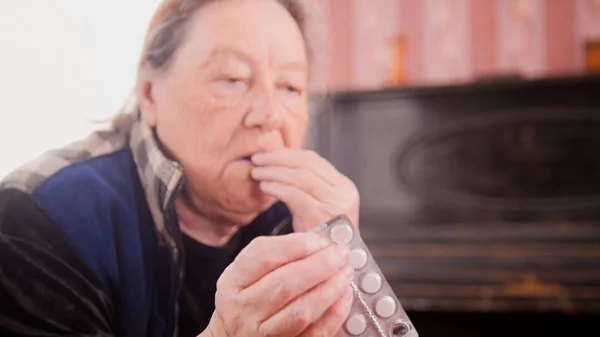 Uma mulher idosa bebe o medicamento — Fotografia de Stock