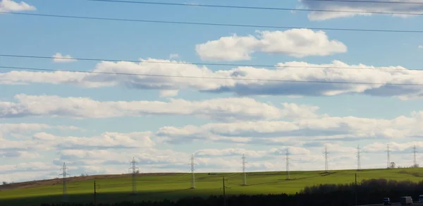 Summer lanscape with electricity pylons and lines at field, sunny day — Stock Photo, Image