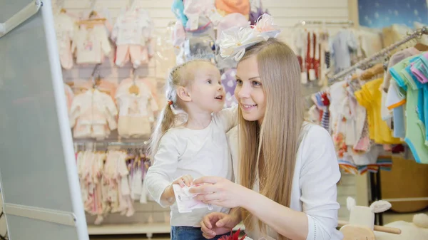 Niña y su mamá feliz en la tienda de niños — Foto de Stock