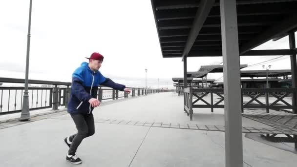 Akrobatiska tonåring pojke utföra volter och kullerbytta utomhus - stedycam slow motion — Stockvideo