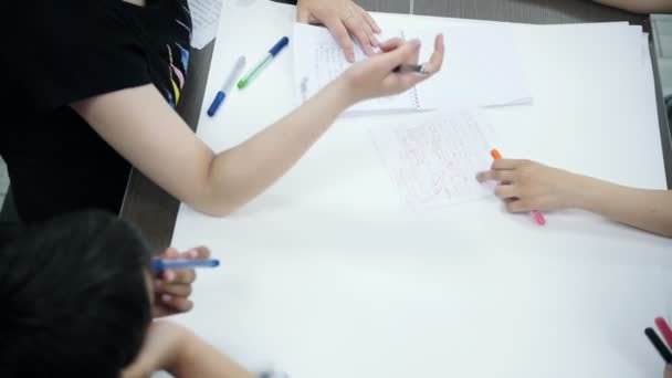 Kinderen tekenen en schrijven op een groot vel papier — Stockvideo