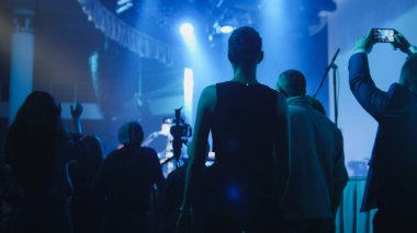 İnsanlar sahne yanında bir konser sırasında stand.