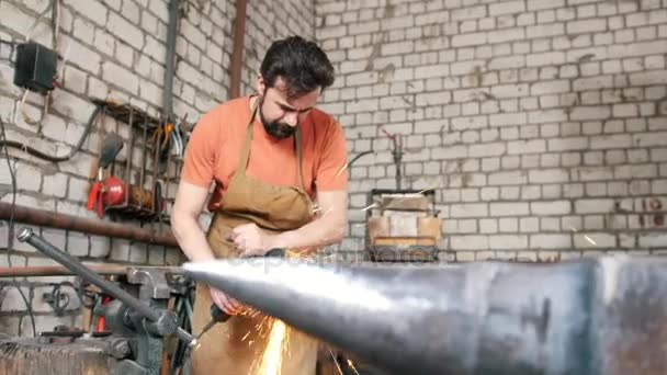 Svalnatý muž pracující s kotoučovou pilou v kovárně — Stock video