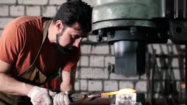 Erimiş metal bir demirci elinde baskı altında işlenir