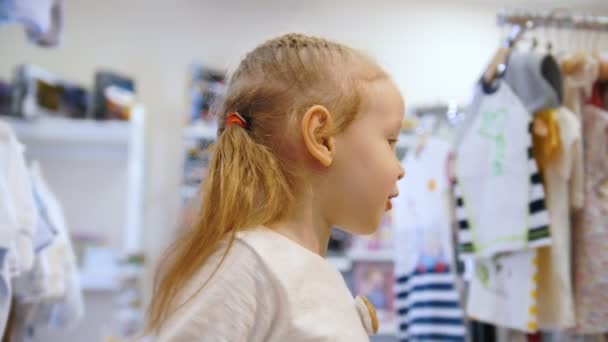 Linda menina loira na loja de brinquedos para crianças — Vídeo de Stock