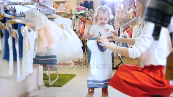Mother and daughter consider blue summer dress with floral pattern — Stock Video