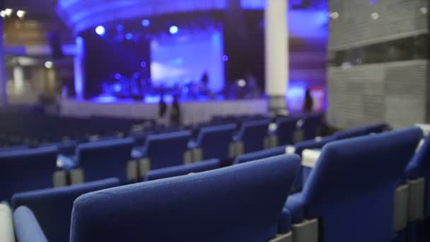 Dużo niebieskich krzeseł w sali koncertowej, de-koncentruje się — Wideo stockowe