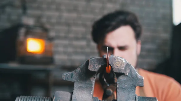Couteau en métal plié forgeron avec gripe dans une forge d'atelier, portrait — Photo