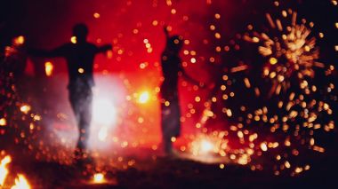 Gece sahilde bulanık havai fişek ateş-performans gösterisi