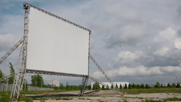 Empty screen of open car cinema - time-lapse of billboard in front of clouds at sunny day — Stock Video