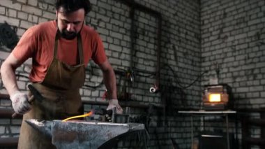 Smith bir sıcak çubuk üzerinde çekiçle bayıltır.