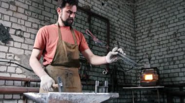 Demirci elinde bıçak boşlukları maşayla tutar.