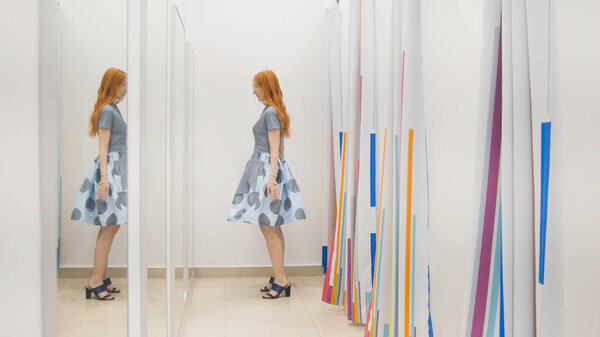 Shopping for woman. A girl trying on a dress in front of a mirror