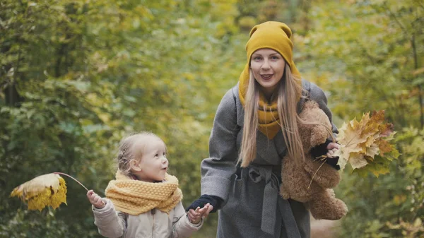 Mujer rubia con hija pequeña en el parque de otoño — Foto de Stock