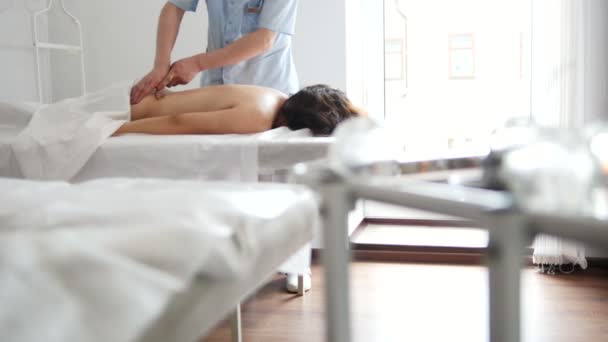 Spa. Het meisje krijgt een massage in de onderrug — Stockvideo