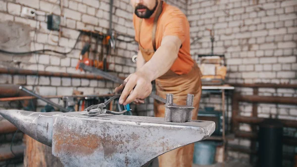 Smith bir sıcak çubuk üzerinde çekiçle bayıltır.