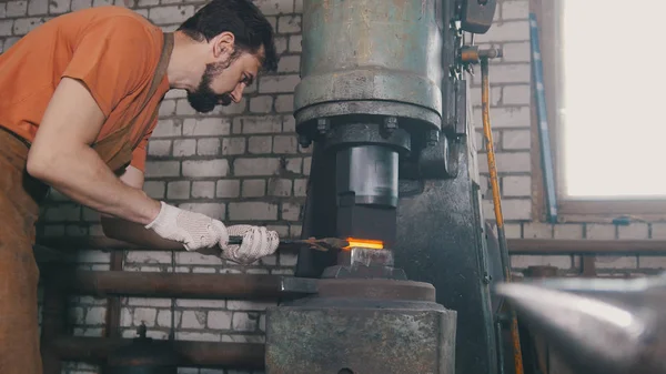 Uomo fabbro forgia il metallo al martello meccanico - piccola impresa — Foto Stock