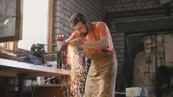 Broyage d'outils métalliques avec étincelles - atelier de forge — Photo