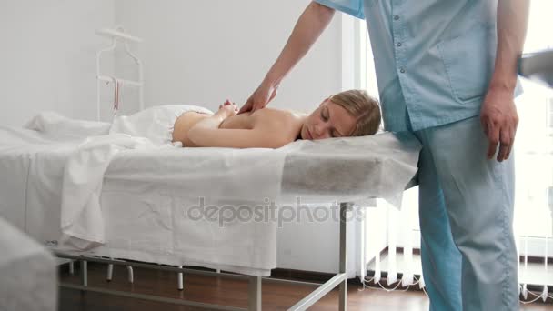 Blonde young woman receiving massage at spa. Relaxation treatment for caucasian model, slider — Stock Video