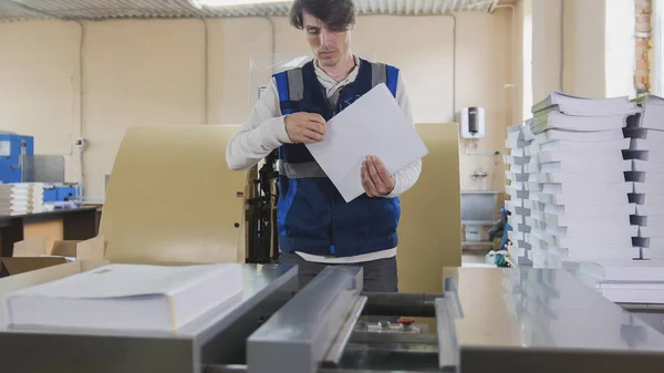 Uomo lavoratore vicino alla macchina da stampa, industria poligrafica — Foto Stock