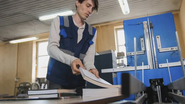 Il lavoratore inserisce fogli di carta alla macchina da stampa, industria del poligrafo — Foto Stock