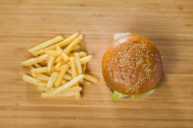 Burger kesme tahtası üzerinde patates ile
