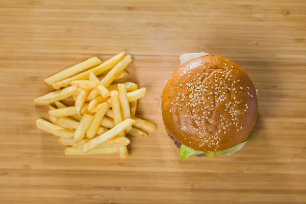 Burger with potatoes on cutting Board — Stock Photo, Image