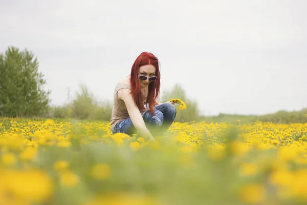 Fille aux cheveux roux dans le domaine des pissenlits — Photo