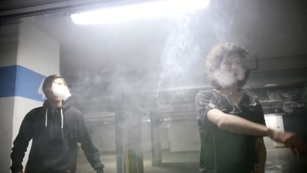 Deux gars dans un parking dans un nuage de fumée — Video