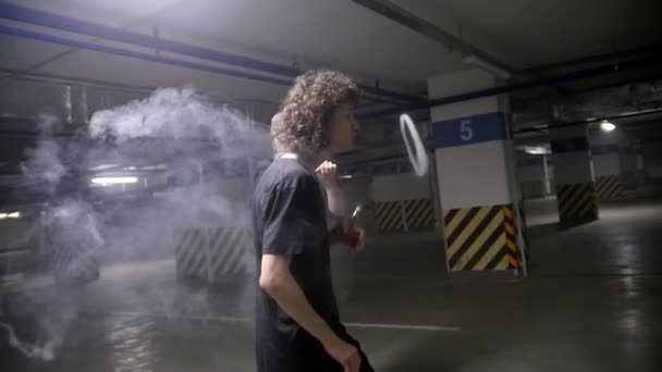 Riccio ragazzo lasciare fuori un anello di fumo dalla sua bocca — Video Stock