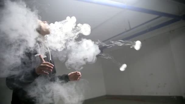 A young man blows up smoke rings. In the parking — Stock Video