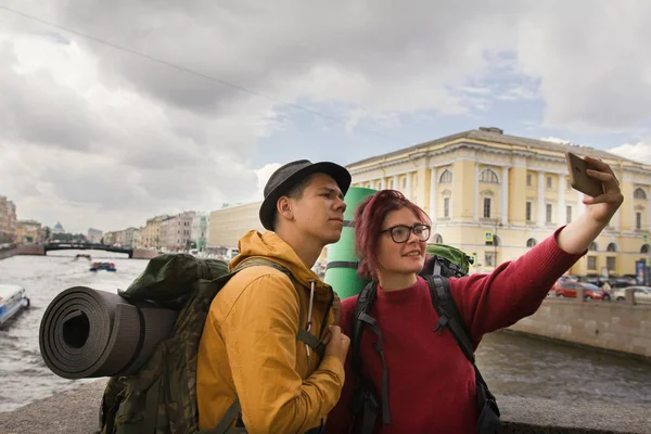 Pareja joven de turistas tomando selfies en el fondo de la ciudad —  Fotos de Stock