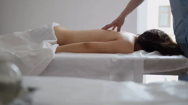 Fisioterapeuta do sexo masculino massageando mulheres de volta no consultório médico — Fotografia de Stock