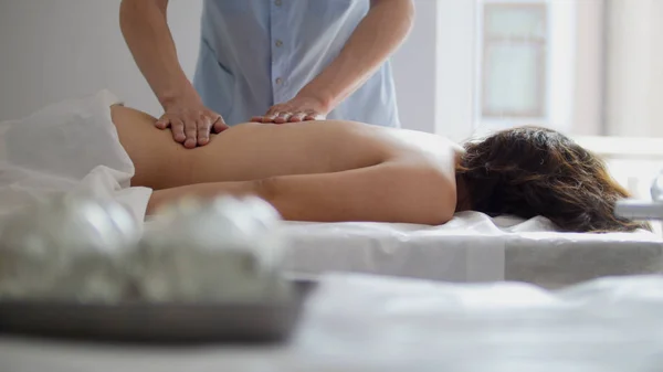 Спа-центр. Дівчині дають масаж в нижній частині спини — стокове фото
