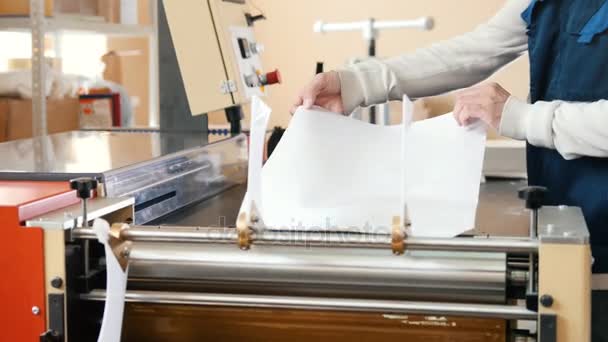 Werknemer werkt bij polygraaf machine, de grafische sector — Stockvideo