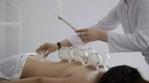 Docteur pose une tasse en verre médical sur le dos d'une femme — Photo