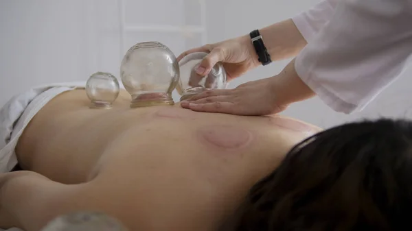 Doktor bir kadın arkası tıbbi cam bardakta kaldırır