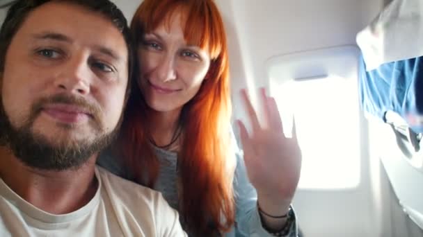Joven hombre y mujer - pasajeros en el avión tomando selfies — Vídeos de Stock