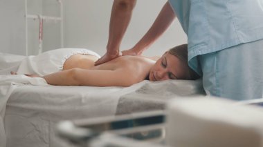 Bel için gevşeme masaj yağı. Adam genç sarışın kadın susam yağı losyonları