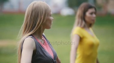 Çekici bir genç kadın parkta esneklik için eğitim gerçekleştirir