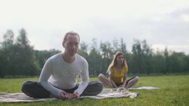 Parkta meditasyon Yoga - instrctor ve kız gerçekleştirir