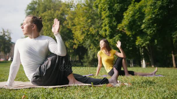 Yoga matutino - instrutor e menina executa meditando no parque — Vídeo de Stock