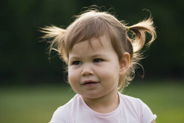 Niña hild jugando en el parque frente a la hierba verde — Foto de Stock